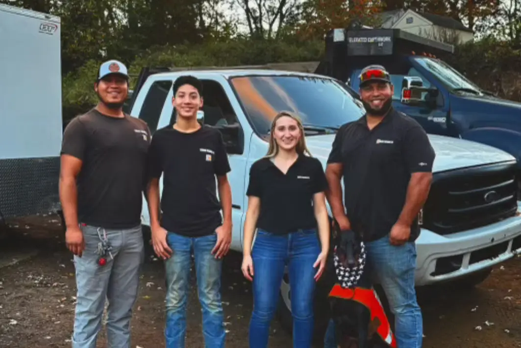 The Elevated Earthwork family and crew in front of company trucks